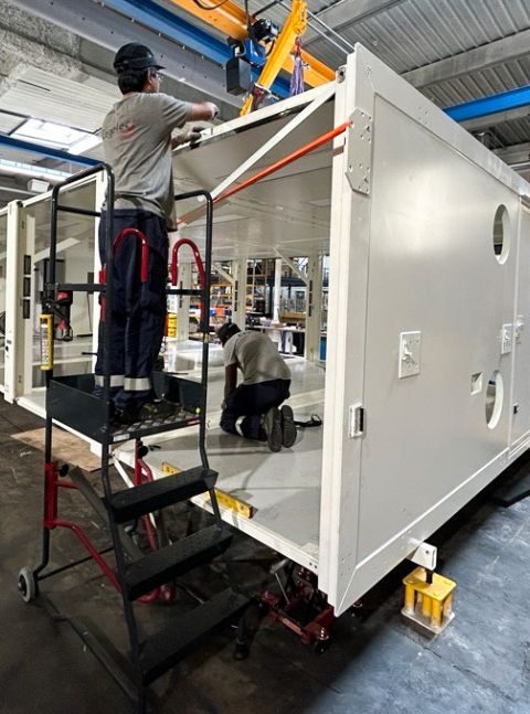 Assemblage de l'Unité Sanitaire Mobile (USM) Polynésie par les équipes CEGELEC Défense dans un atelier industriel dans le cadre de la démarche qualité QSE.