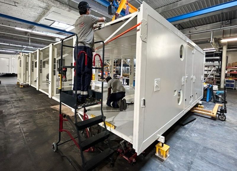 Assemblage de l'Unité Sanitaire Mobile (USM) Polynésie par les équipes CEGELEC Défense dans un atelier industriel dans le cadre de la démarche qualité QSE.