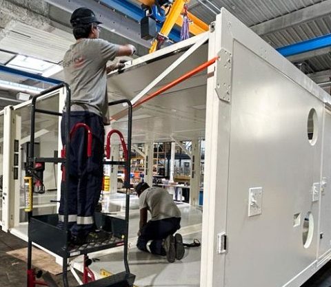 Assemblage de l'Unité Sanitaire Mobile (USM) Polynésie par les équipes CEGELEC Défense dans un atelier industriel dans le cadre de la démarche qualité QSE.