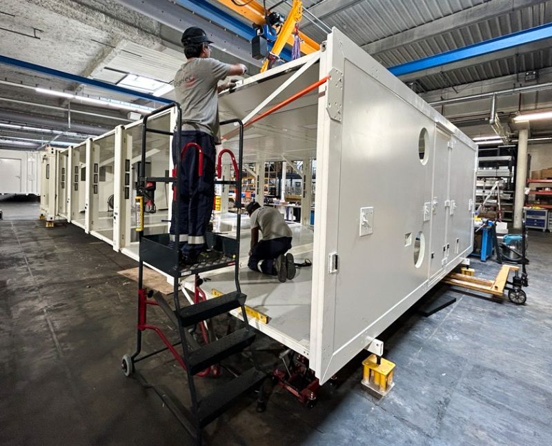 Assemblage de l'Unité Sanitaire Mobile (USM) Polynésie par les équipes CEGELEC Défense dans un atelier industriel dans le cadre de la démarche qualité QSE.
